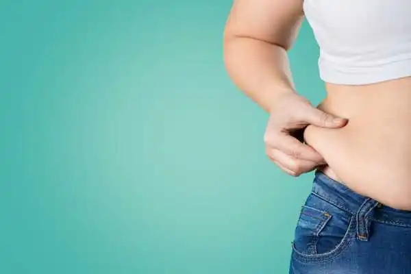 Image of woman pinching her love handles to show weight gain Bournemouth